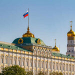 The Kremlin building with the Russian flag and golden domes in the background