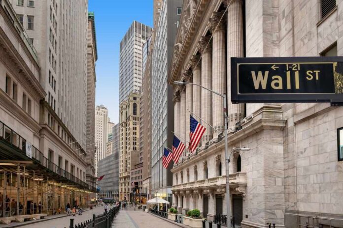 View of Wall Street with skyscrapers and American flags