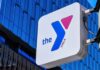 YMCA sign mounted on a modern glass building