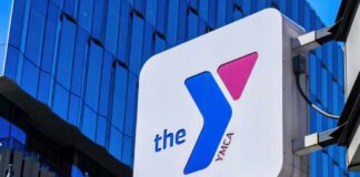 YMCA sign mounted on a modern glass building