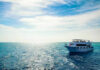 Boat on open sea with blue sky overhead