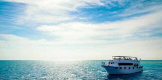 Boat on open sea with blue sky overhead