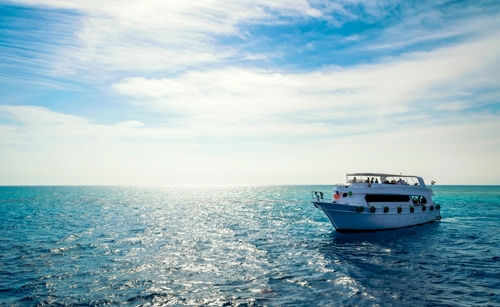 Boat on open sea with blue sky overhead