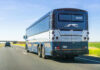 Rear view of a blue intercity coach bus on a highway