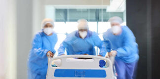Medical team in PPE rushing a patient on a hospital gurney