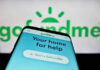 Smartphone displaying GoFundMe app with logo background