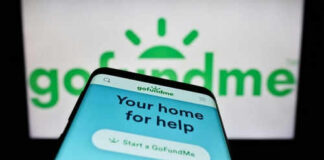 Smartphone displaying GoFundMe app with logo background