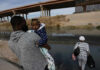 Federal Agencies Face Child Tracking Questions Man carrying child near a body of water