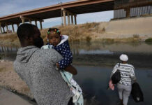 Federal Agencies Face Child Tracking Questions Man carrying child near a body of water