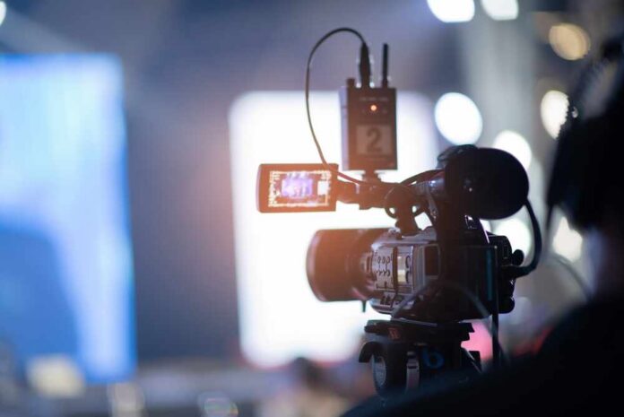Videographer,Close,Up,,Cameraman,,Man,With,Camera,,Movie, Close-up of a video camera set up for filming
