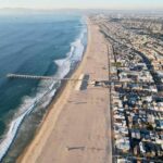 A Family Getaway Became Every Parent’s Fear Aerial view of a beach with a pier and urban area beside the ocean