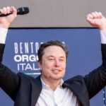 Person with a microphone raising hands in celebration