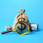 Money bag and magnifying glass on blue background