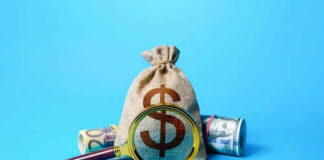 Money bag and magnifying glass on blue background