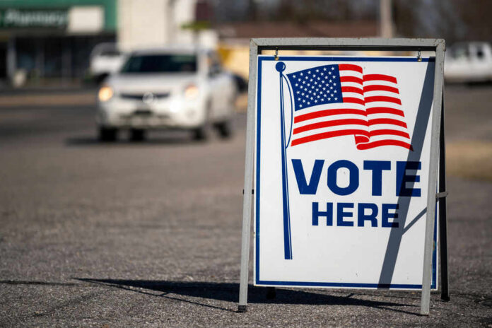 Vote Here sign with American flag.