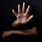 Person with open hand raised toward camera