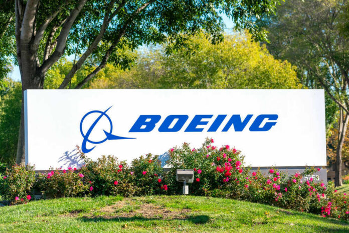 Boeing logo on sign with flowers and trees