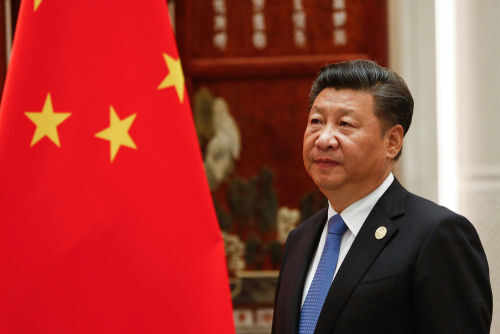 Person standing near a Chinese flag indoors