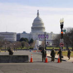 United States Capitol with soldiers and barricades in foreground