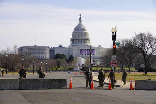 United States Capitol with soldiers and barricades in foreground
