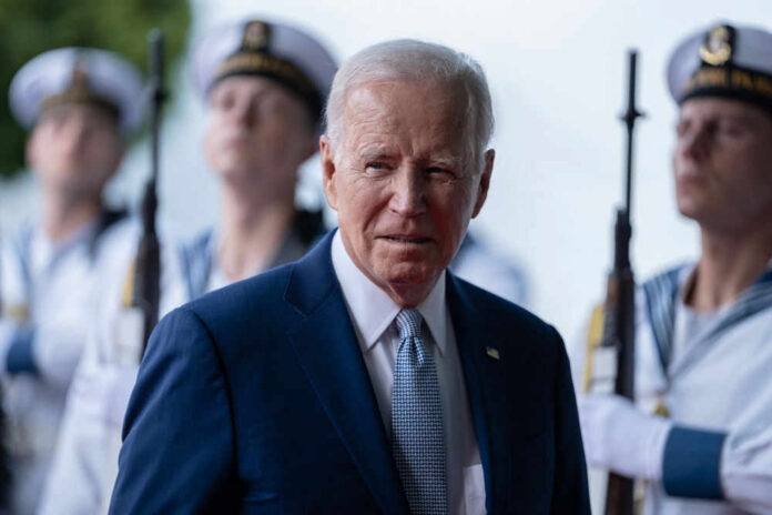 Man in suit with uniformed guards in background