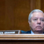 Man sitting at a desk with nameplate Sen Graham