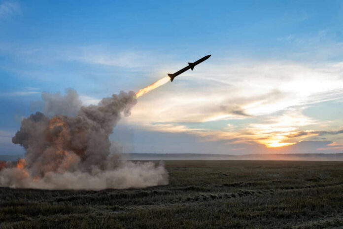 Rocket launching over a field at sunset