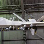 military drone with missiles suspended in a hangar