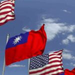 Flags of the United States and Taiwan waving against a blue sky