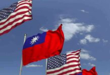 Flags of the United States and Taiwan waving against a blue sky
