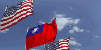 Flags of the United States and Taiwan waving against a blue sky