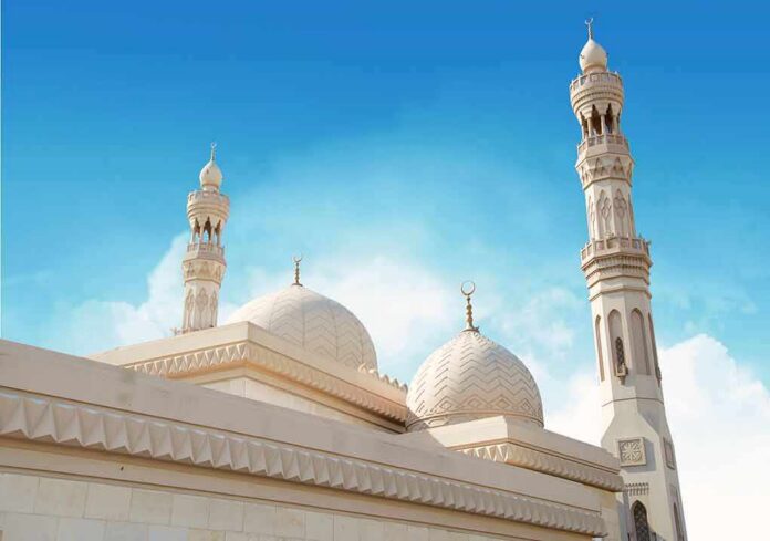 Mosque with domes and minarets against a clear blue sky