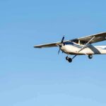 Single-engine airplane flying against clear blue sky