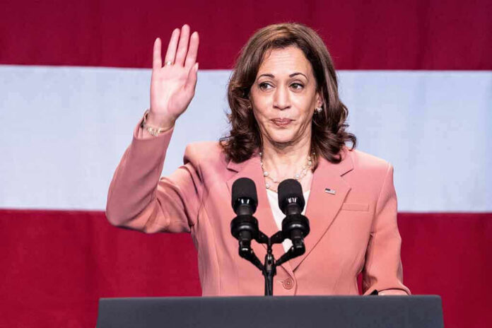 Woman raising her hand while speaking at podium.