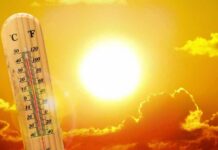 thermometer in front of a blazing sun and orange sky