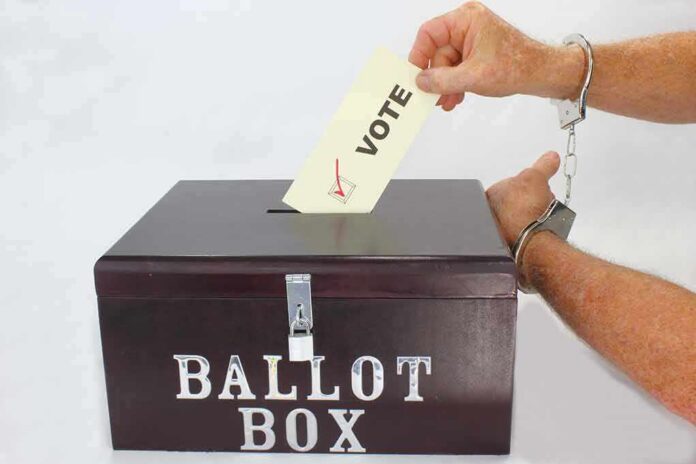 Hand in handcuffs casting a vote into a ballot box