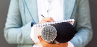Journalist holding microphones and notepad