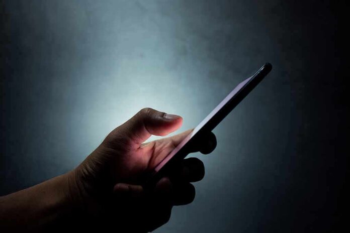 Hand holding a smartphone in the dark