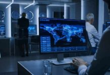 Analyst monitors world map data on large screen in control room