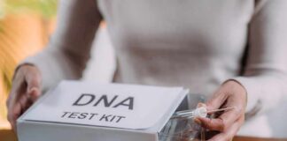 Person handling a DNA test kit with swabs on a table