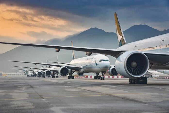 Commercial airliners lined up on an airport taxiway at dusk