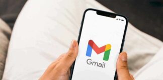 Hands holding a smartphone displaying the Gmail app logo