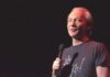 comedian holding a microphone on stage