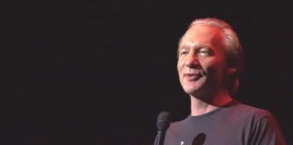 comedian holding a microphone on stage