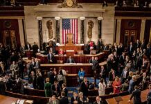 Leonard Lance and Claude Guéant among lawmakers on a legislative chamber floor