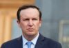 Chris Murphy in a navy suit and blue tie outdoors