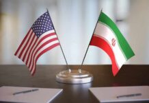 Fiery UN Showdown: Seats Go Empty United States and Iran desk flags on a stand