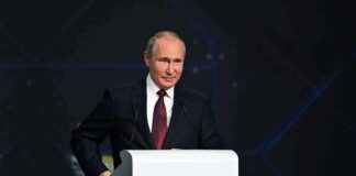 person in suit speaking at a podium
