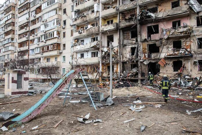 Damaged apartment building behind a playground slide