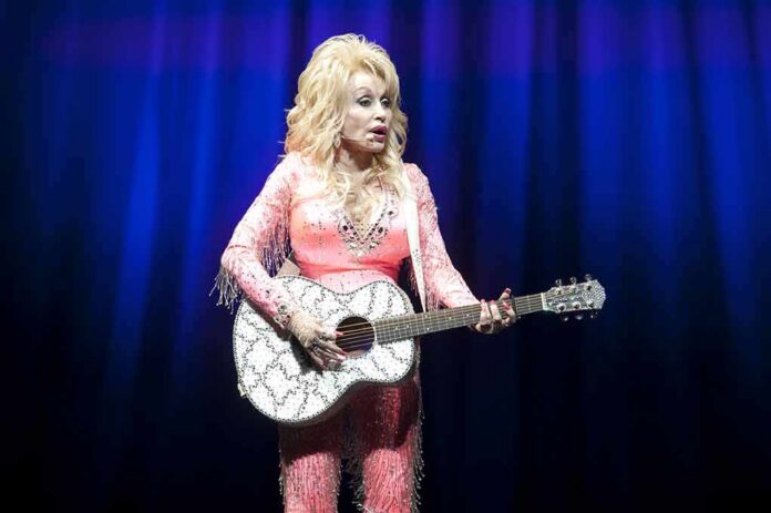 shutterstock_512117083 Singer in pink outfit playing a glittery acoustic guitar on stage